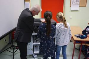 Carsten Wulfänger übergibt die Computer an die Schülerinnen und Schüler