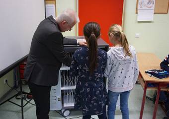 Carsten Wulfänger übergibt die Computer an die Schülerinnen und Schüler