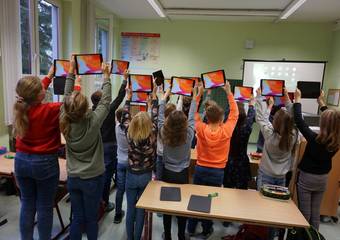 Stolz präsentieren die Schülerinnen und Schüler ihre neuen Unterrichtsmittel