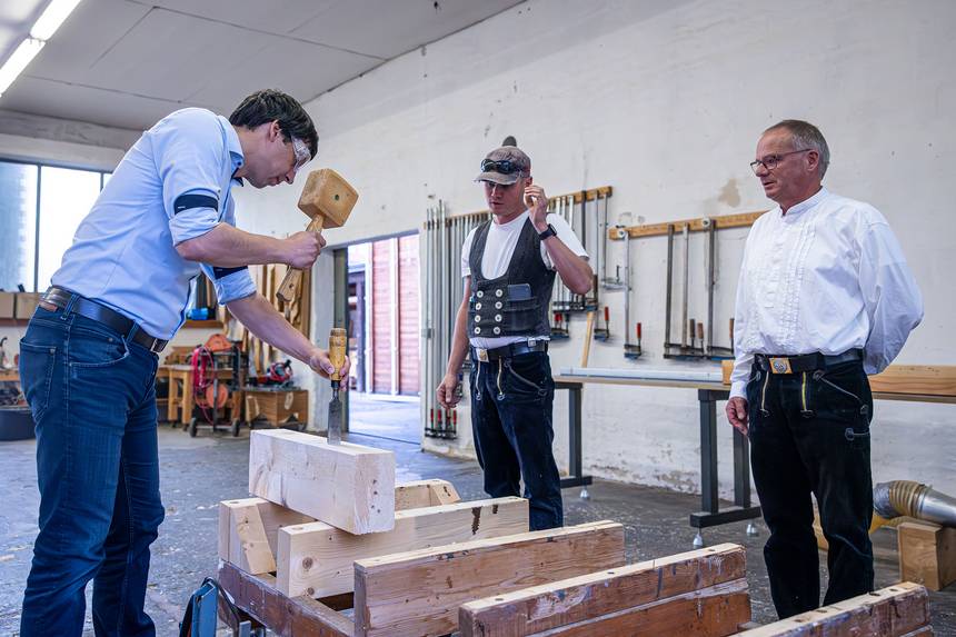 Unter Aufsicht der Meister Marco (von rechts) und Tobias Vack versucht sich der Landrat selbst, ein Zapfenloch herzustellen. ©Stefan Rühling pressefoto vack