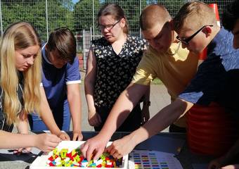 Annemarie Kock zeigt den Schülern Lego-Steine, die mit Brailleschrift versehen sind. © Johanna Michelis