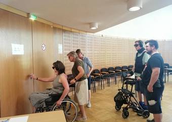Im Rollstuhl sitzend oder mit Rollator sollen die Teilnehmer eine Tür öffnen. © Johanna Michelis